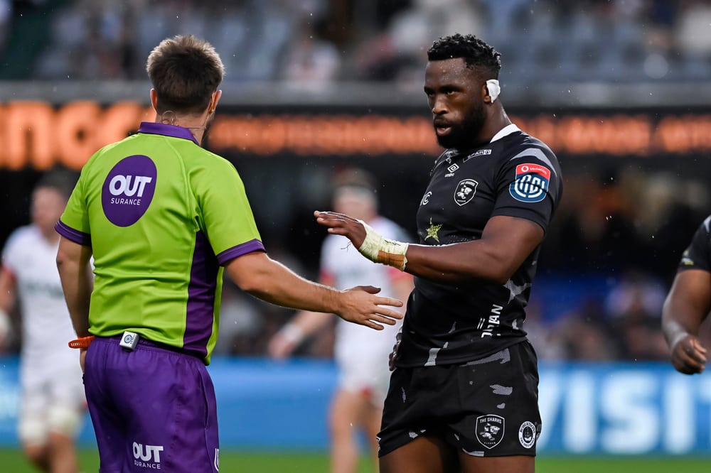 Ben Whitehouse in conversation with a rugby player in a black shirt