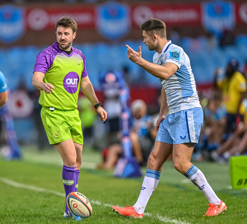 Ben Whitehouse listening to a rugby player in a light blue shirt