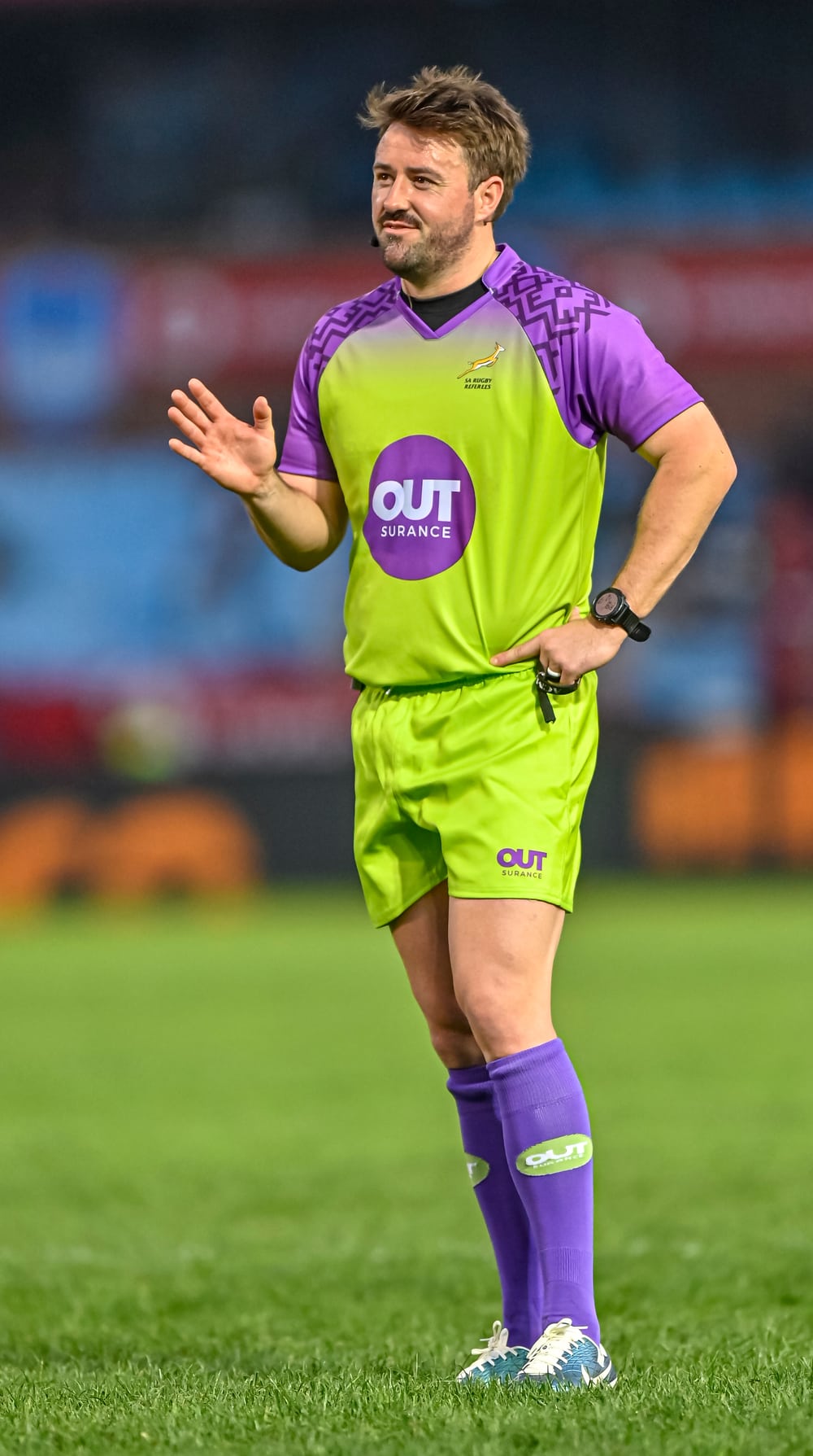 Ben Whitehouse refereeing in a green and purple match official's kit