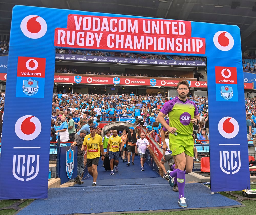 Ben Whitehouse running through the stadium entrance towards the pitch