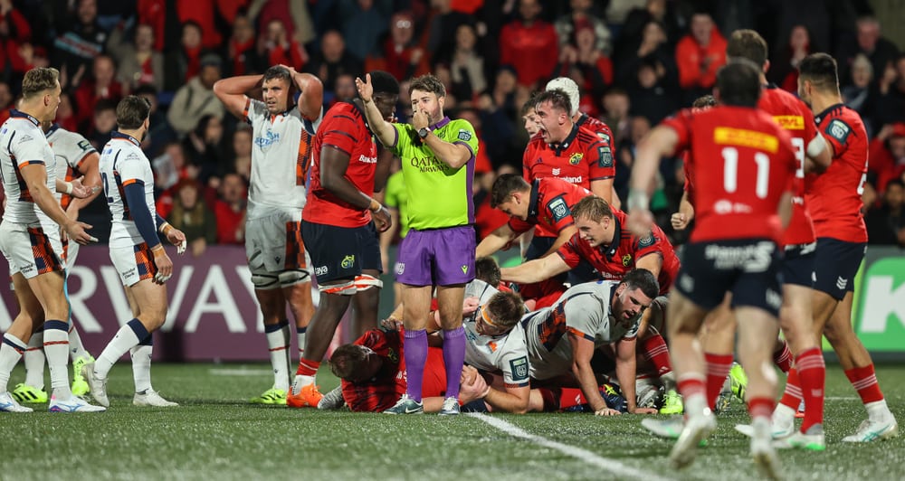 Ben Whitehouse blowing his whistle with rugby players gathered around him